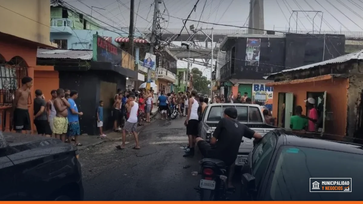 Jóvenes celebran un teteo en las calles de Santo Domingo durante lluvias intensas.